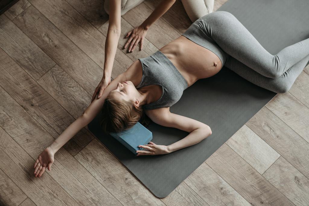 A Pregnant Woman in Gray Activewear Exercising at Home